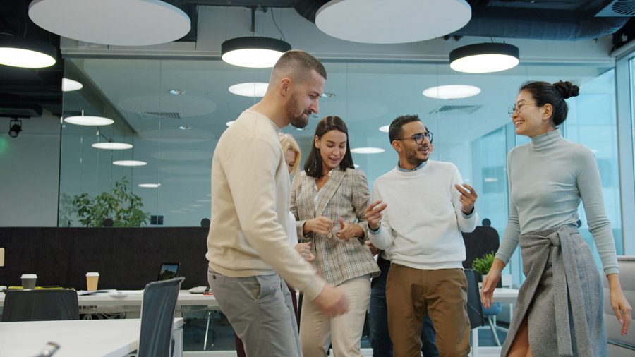 Time de colaboradores conversando em empresa, segurados pelo seguro de vida em grupo.