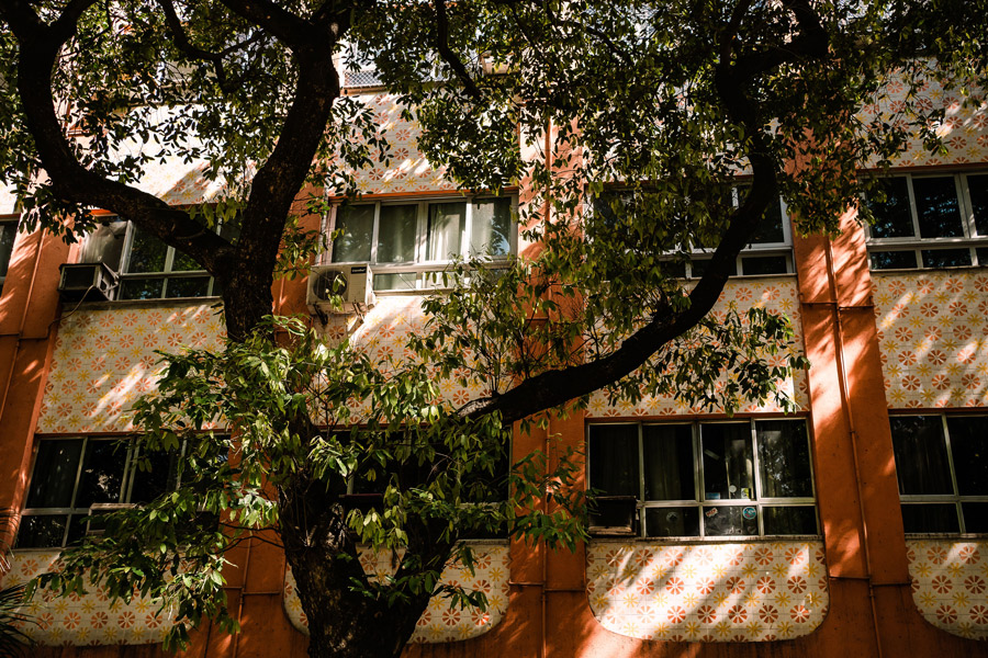 Fachada de prédio, mostrando janelas de apartamentos vistas da rua.